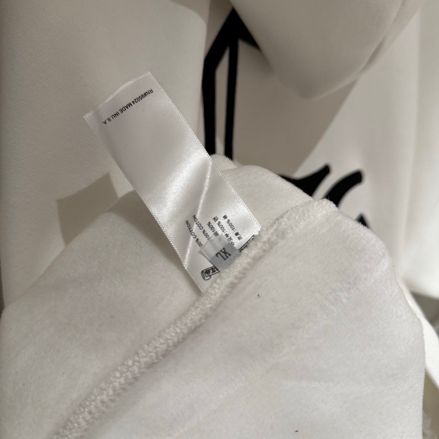 White hoodie with brand tag at collar and inner stitching