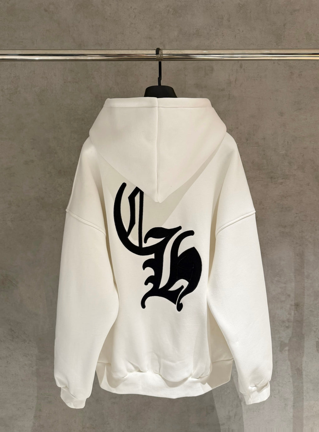 White long-sleeve zip hoodie with black back graphic and hood