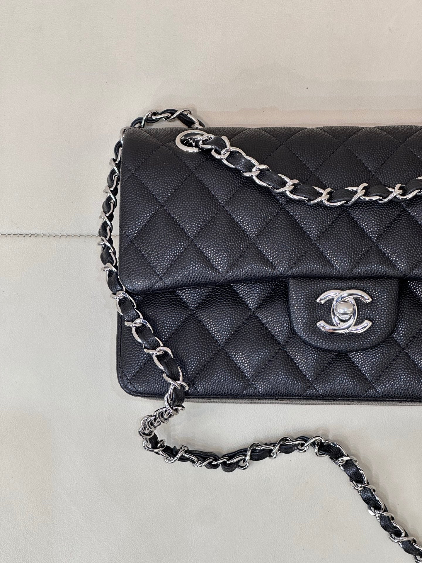 Chanel quilted shoulder bag close-up, chain strap and CC logo on flap