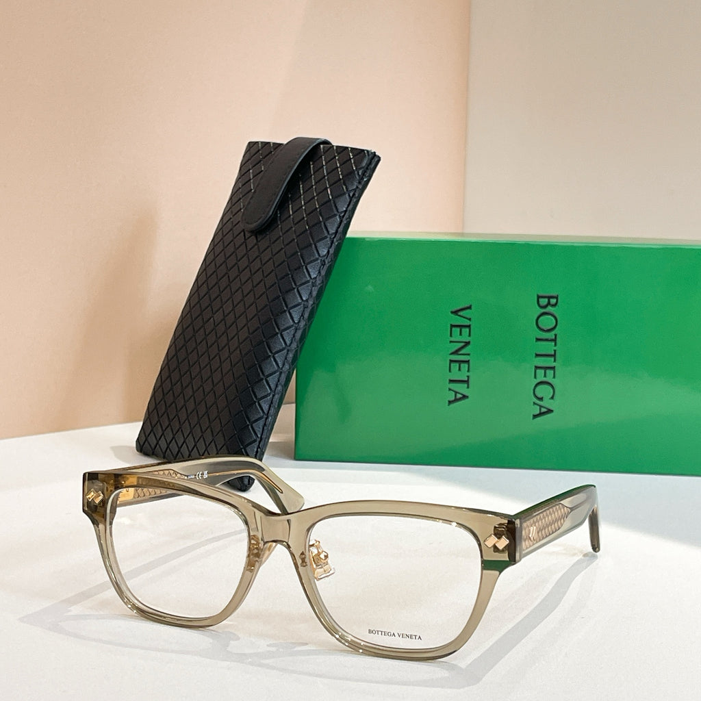 Light gold eyeglasses with clear frame panels and gold logo accents