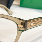 Clear eyeglasses with gold hinge hardware and patterned temple detail