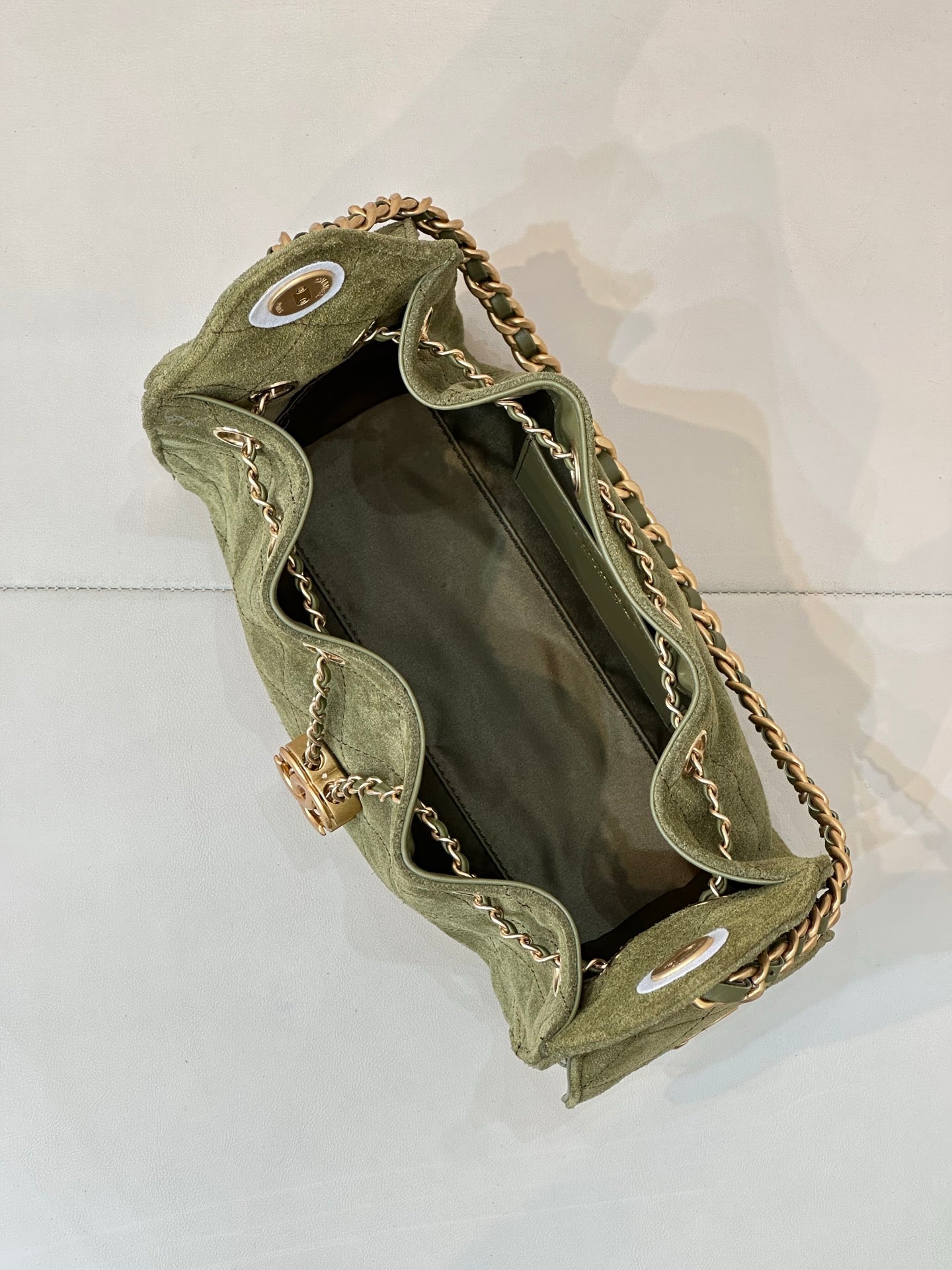 Chanel mini handbag in olive green with open top and gold chain strap interior view