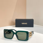 Green square sunglasses with gold Versace logo temples and clear green-tinted lenses.