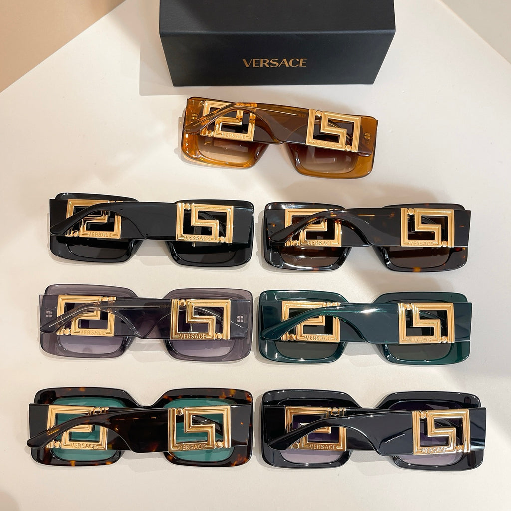 Tray of assorted square sunglasses with gold Versace logo temples and varied lenses.