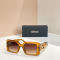 Amber square sunglasses with gold Versace logo temples and dark lenses.