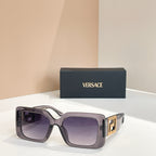 Lilac square sunglasses with gold Versace logo temples and purple-tinted lenses.