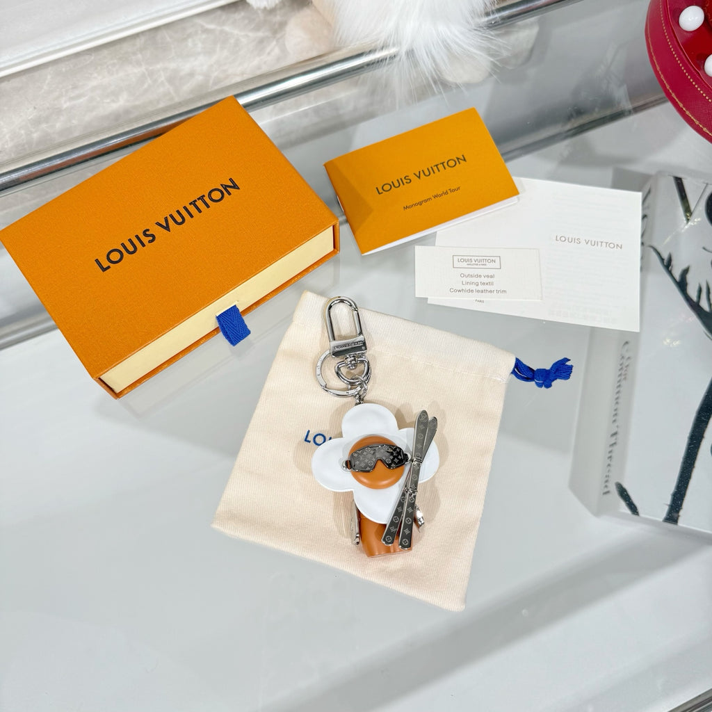 Louis Vuitton keychain charm on gift box display, white flower and orange figure with ring