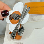 Louis Vuitton keychain charms with orange leather, black monogram panels, silver clips