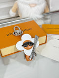 Louis Vuitton keychain charm with white flower, orange figure, silver clasp and ring