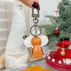 Louis Vuitton keychain charm with silver top ring and orange figure body, white flower wings