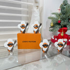 Louis Vuitton charm keychains beside orange brand box, silver clips and white caps