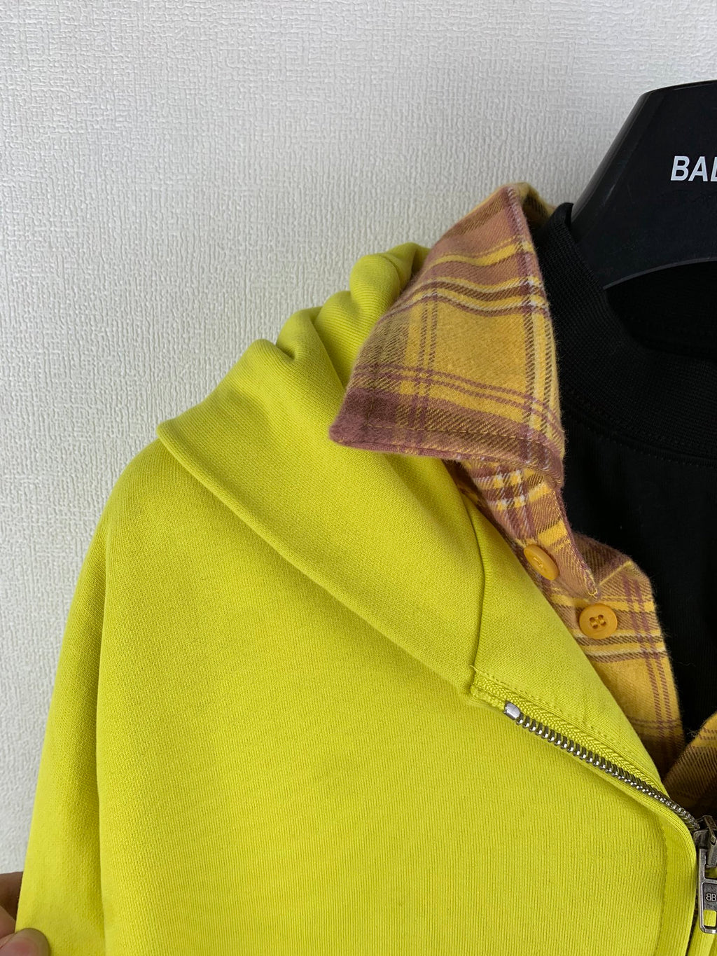 Lime green zip jacket close-up with plaid inner hood lining and metal zipper pull