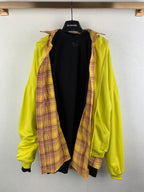 Bright lime green zip-up hooded jacket with plaid lining peeking from the open front