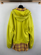 Lime green zip-up hooded jacket with plaid hem peeking below the hood