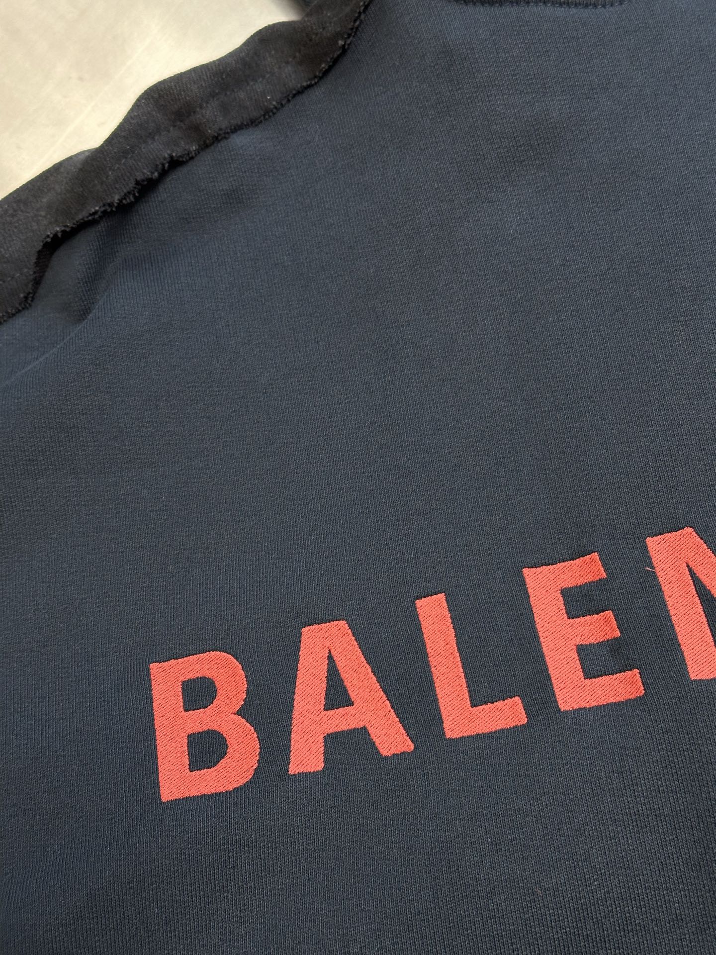 Dark blue hooded jacket front with red BALENCIAGA lettering print