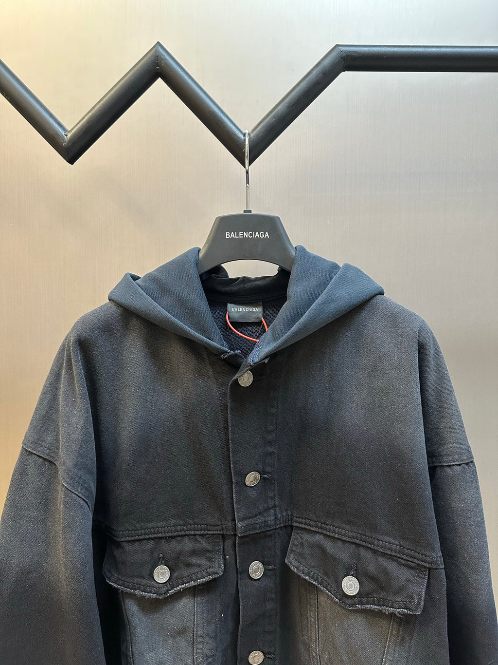 Dark blue hooded denim jacket detail view with snap button chest pockets