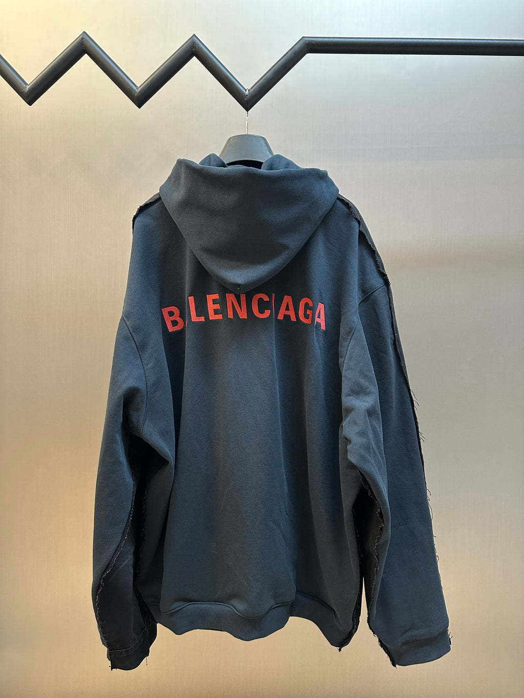 Dark blue hooded jacket with large red BALENCIAGA logo on back
