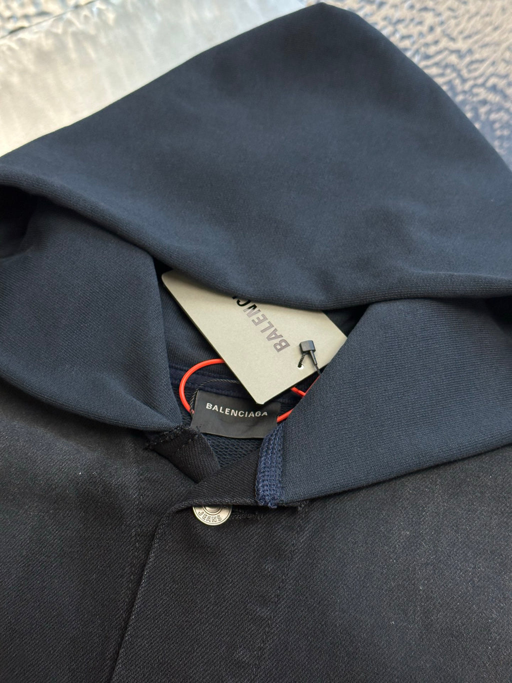 Dark blue hooded jacket with interior neck label and button closure