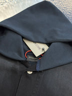 Dark blue hooded jacket with interior neck label and button closure