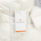 White puffer jacket close-up with snap button front and hanging product tag