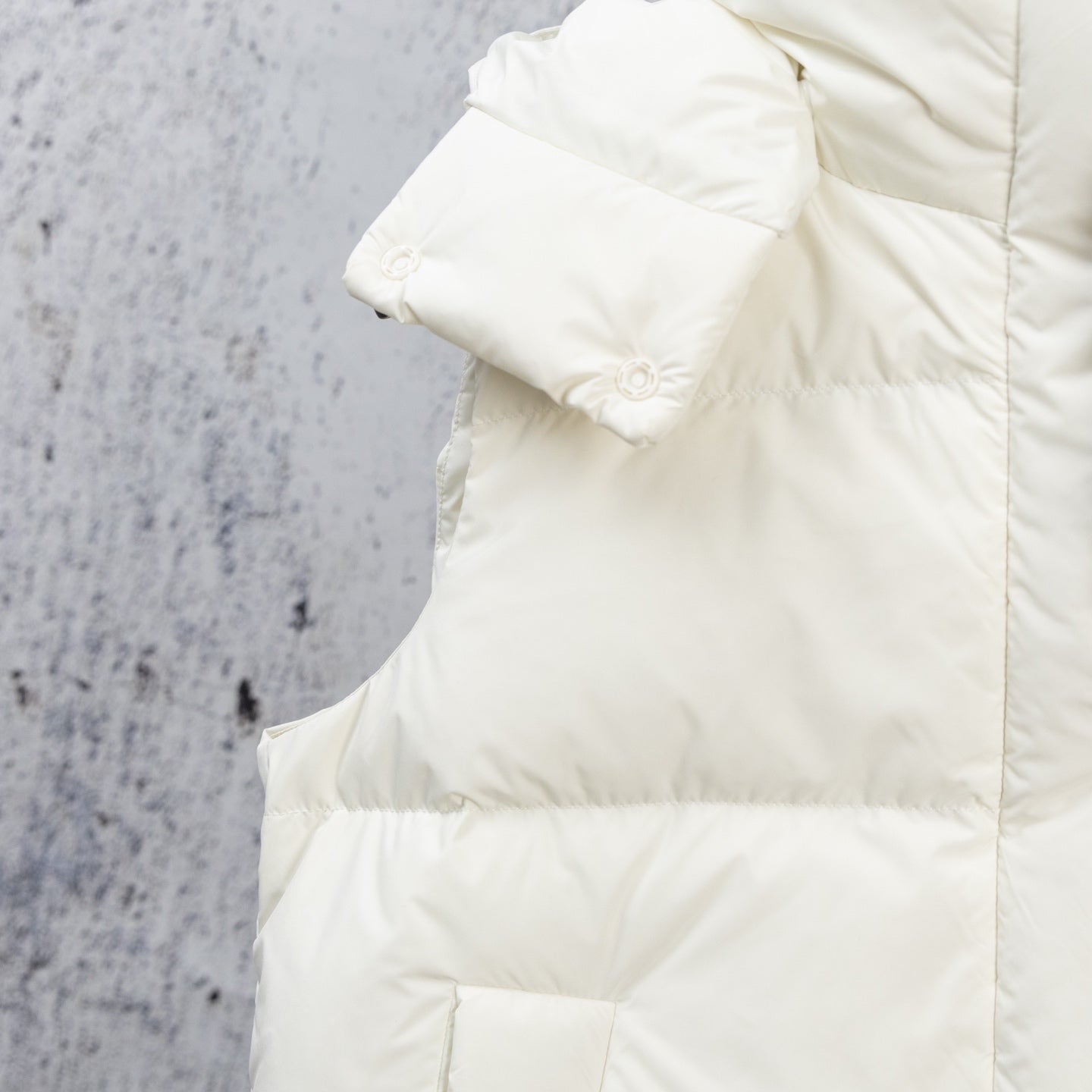 White puffer jacket shoulder and sleeve with quilted padding and cuff detail