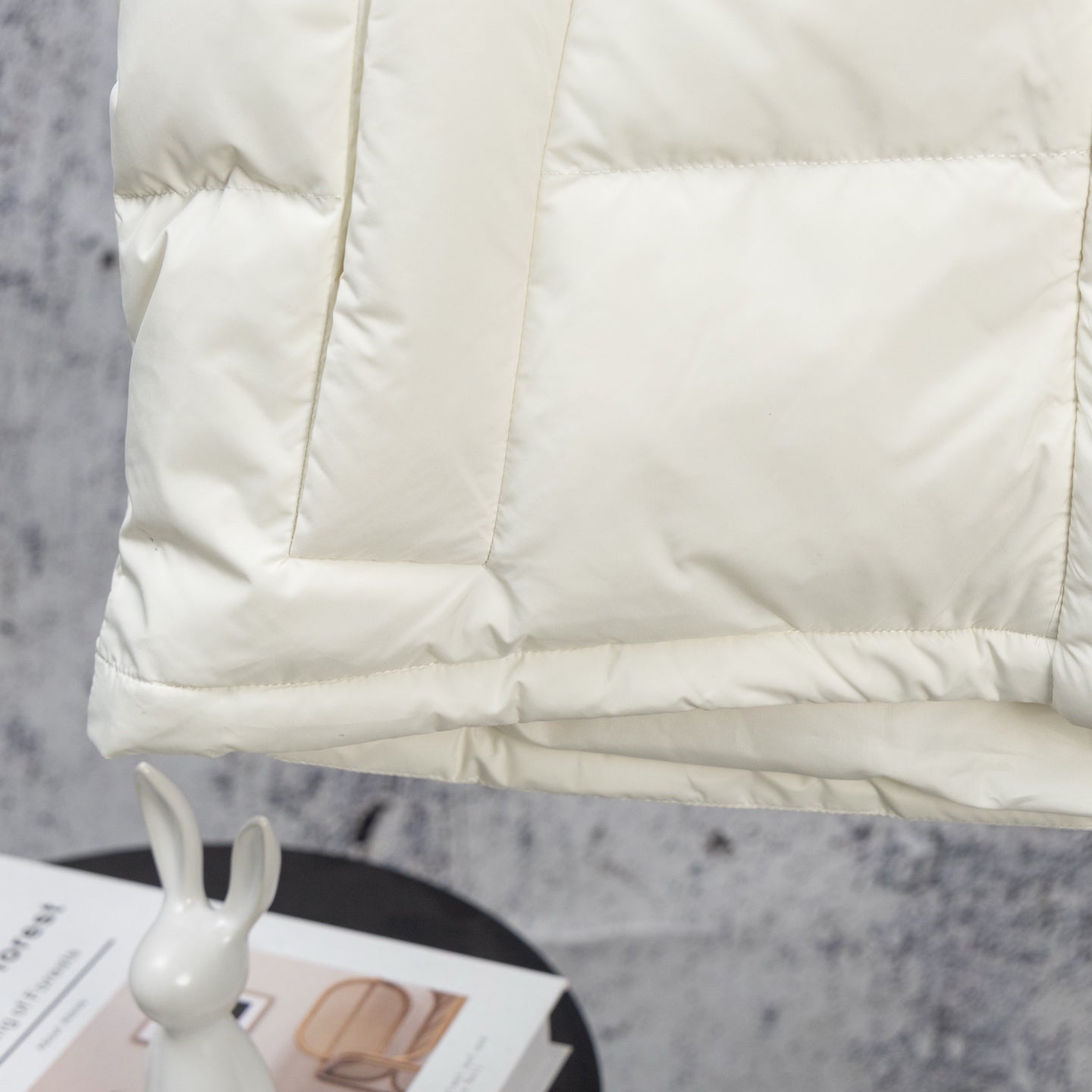 White puffer jacket lower panel with horizontal quilting and stitched hem