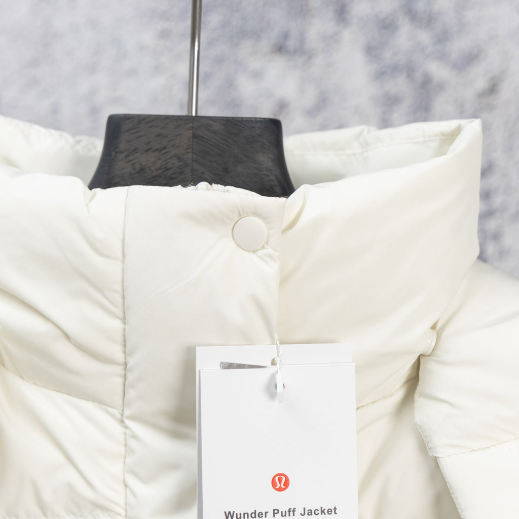 White puffer jacket with quilted panels and snap button front, close-up