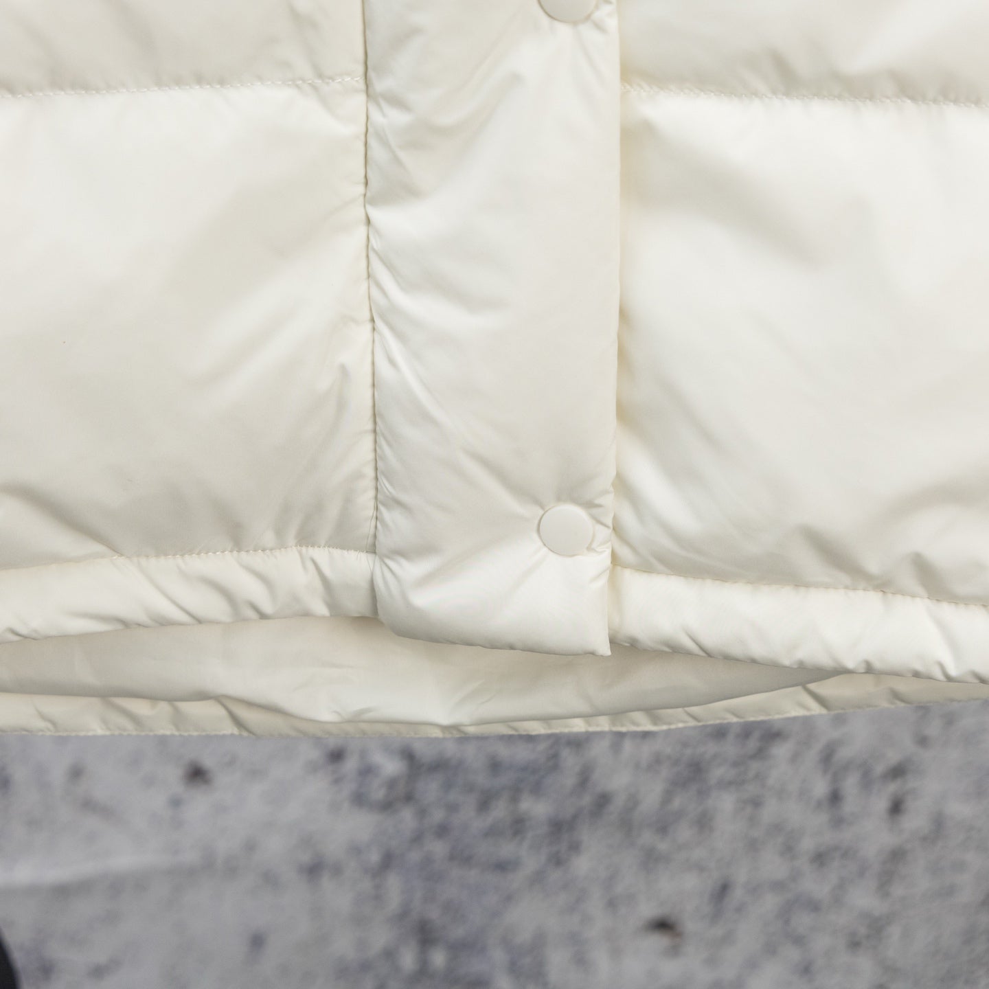 White puffer jacket center front panel with snap button and vertical seam