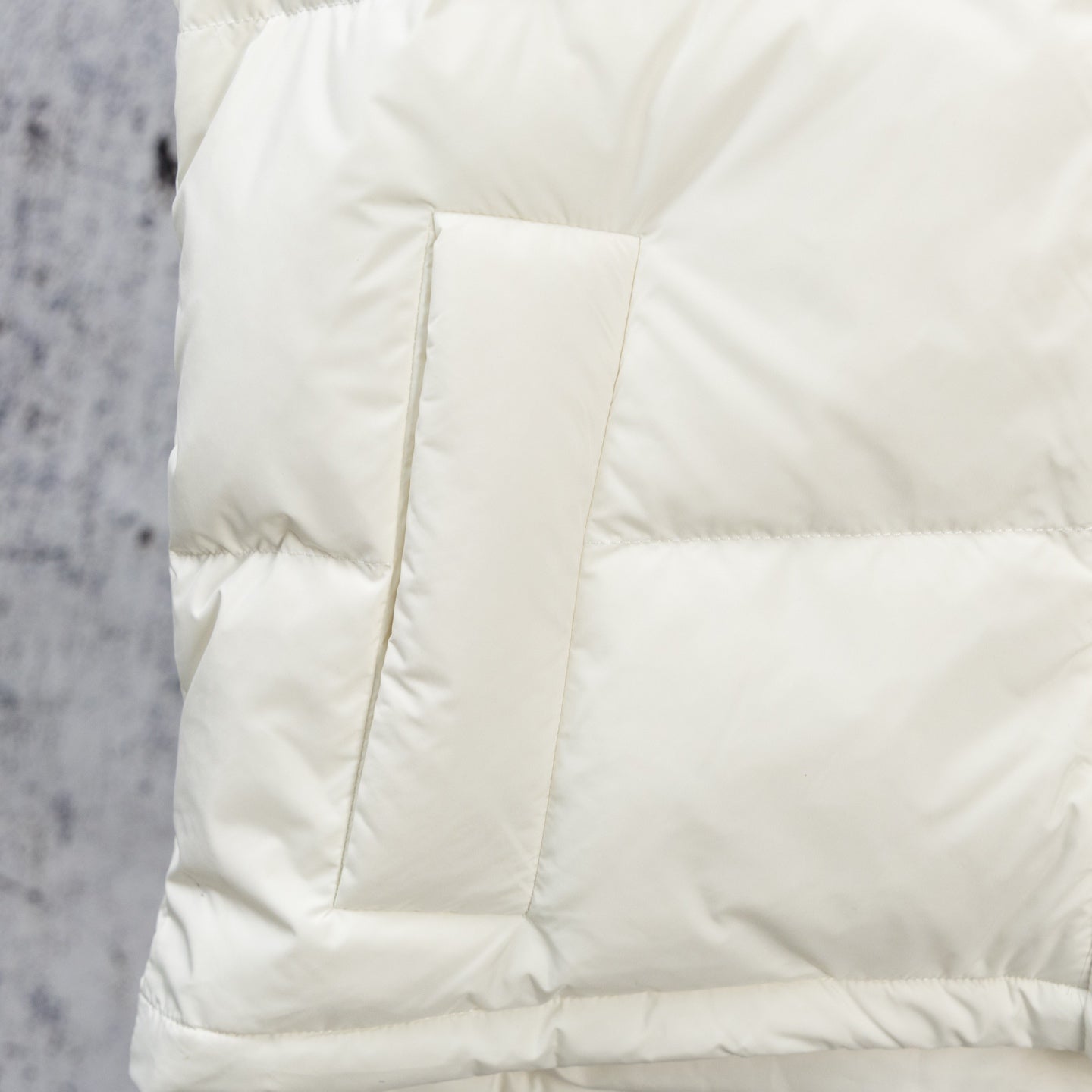 White puffer jacket side panel with quilted box stitching and seam lines