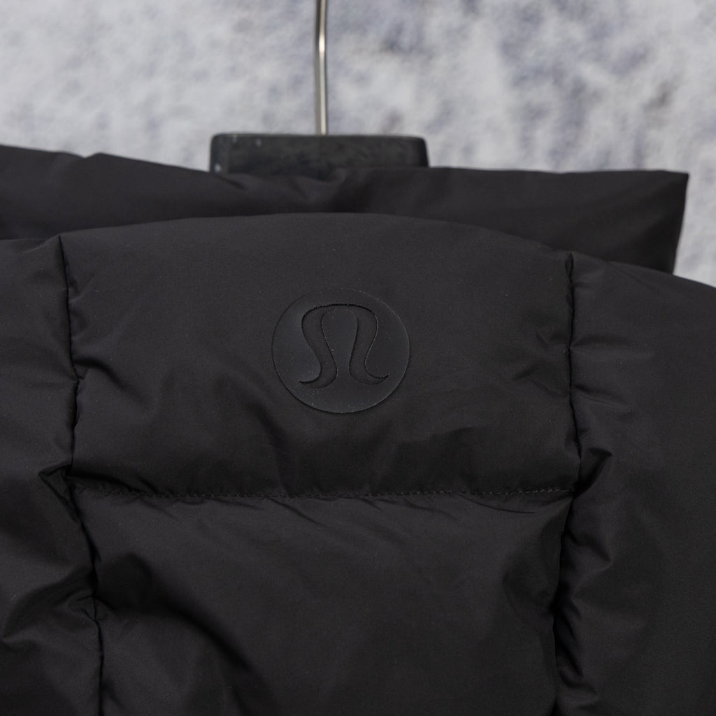 Black puffer vest back with embossed logo badge near collar
