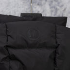 Black puffer vest back with embossed logo badge near collar