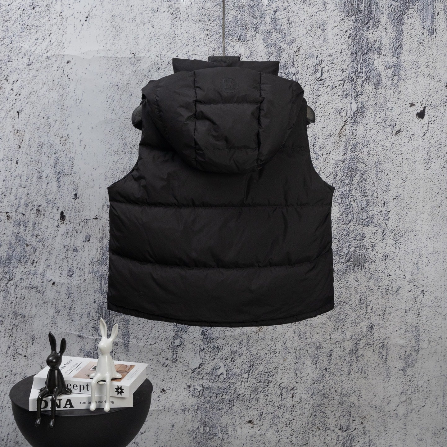 Black hooded puffer vest with front pockets and zip