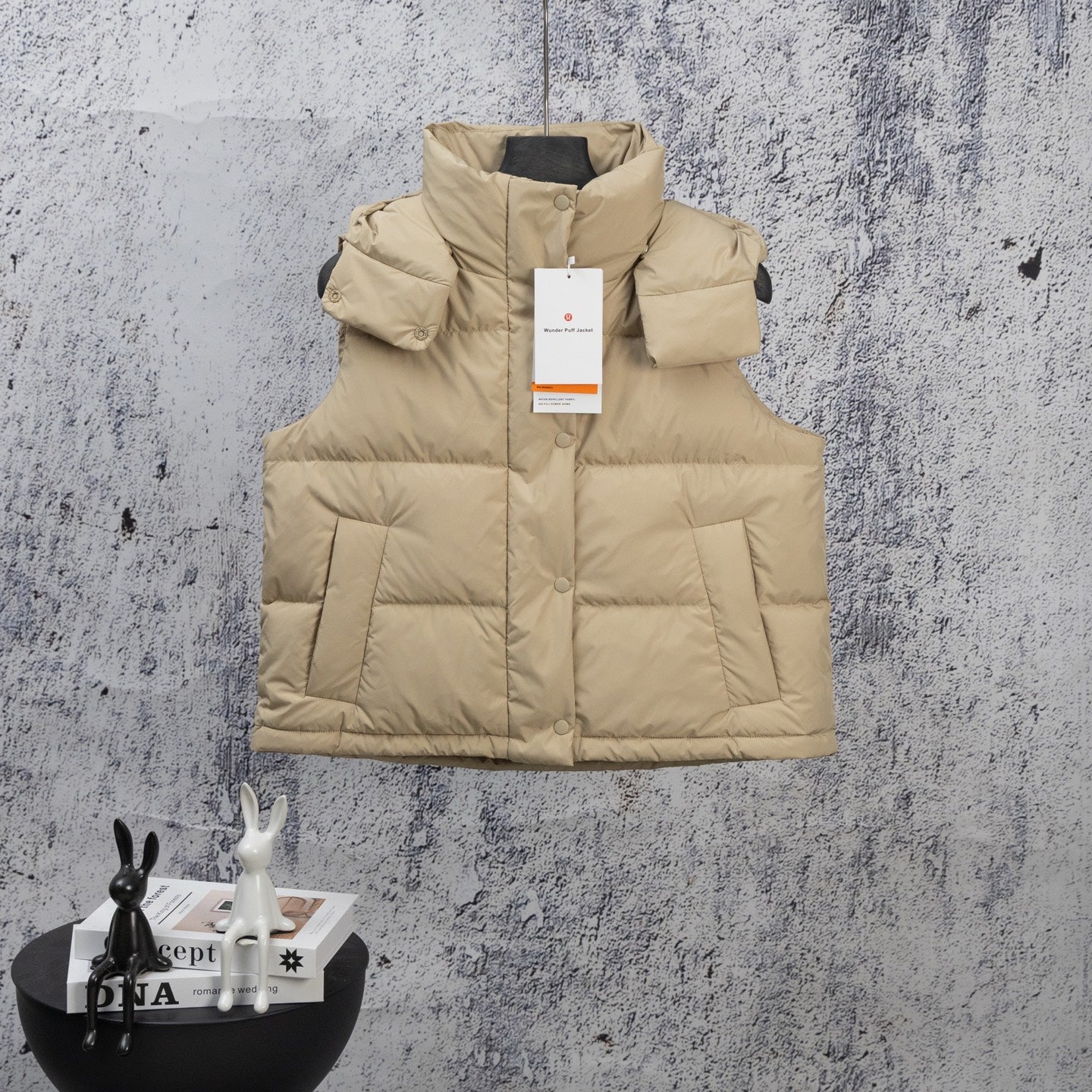 Beige puffer vest with hood, front snap buttons, and quilted panels