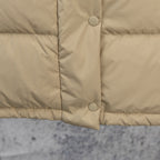 Beige puffer jacket front with two snap buttons and quilted lower panel