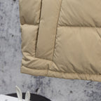 Beige puffer jacket hem with horizontal quilt stitching and padded cuff edge