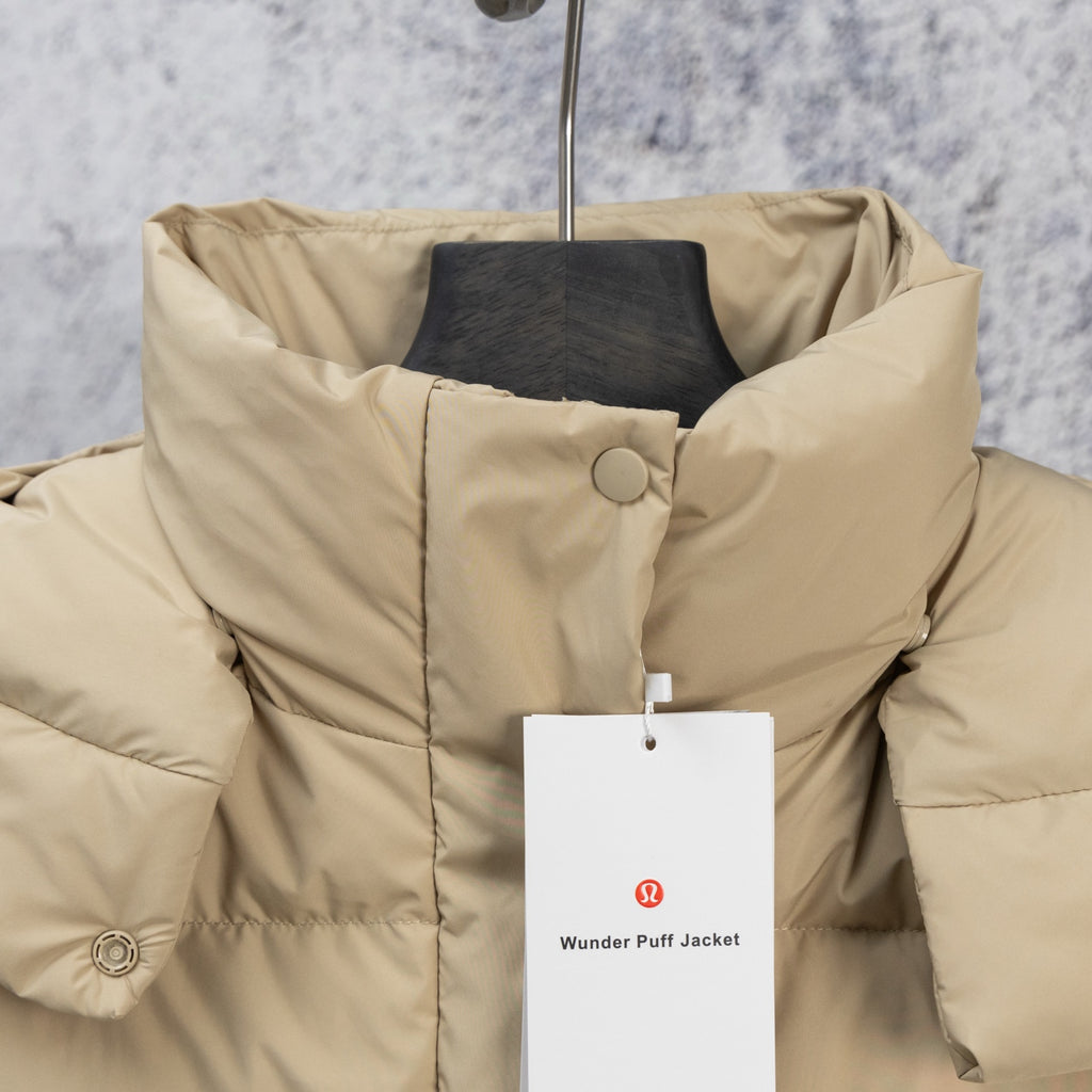 Beige puffer jacket with high collar and snap front, close view on chest
