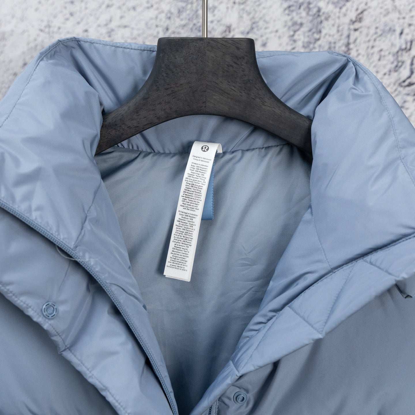 Light blue puffer vest inside view with label at center and wide open collar