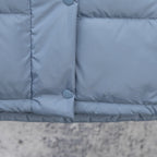 Light blue puffer vest front with two snap buttons and padded lower panel