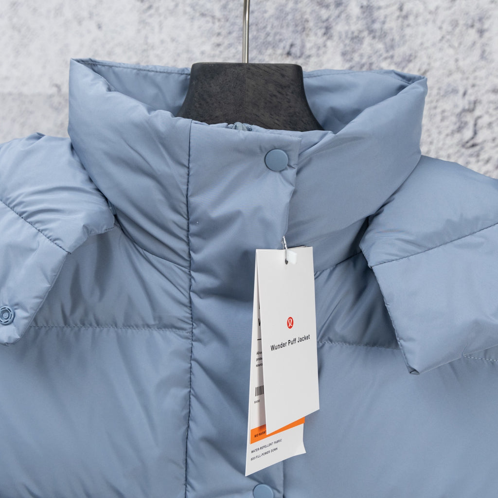 Light blue puffer vest close-up with stand collar and snap button placket
