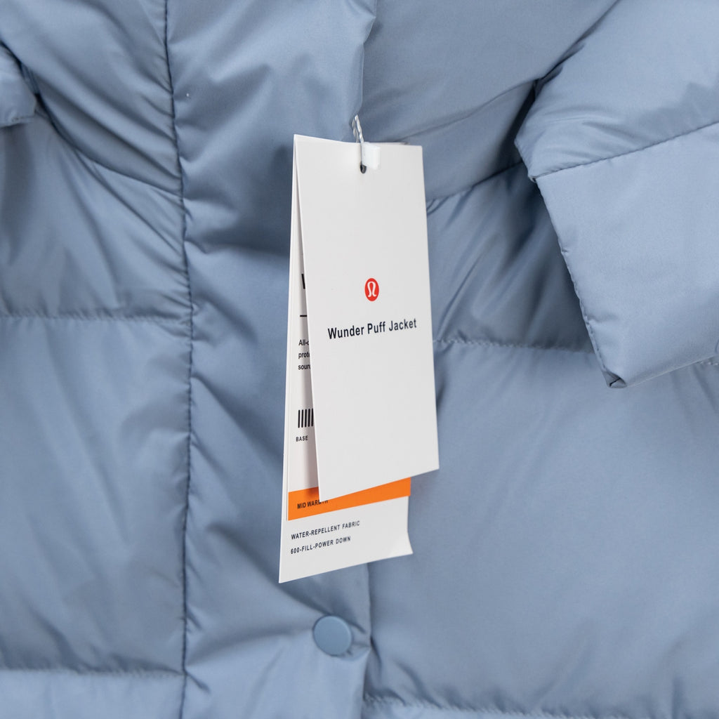 Light blue puffer vest with product tag on front and visible quilting seams