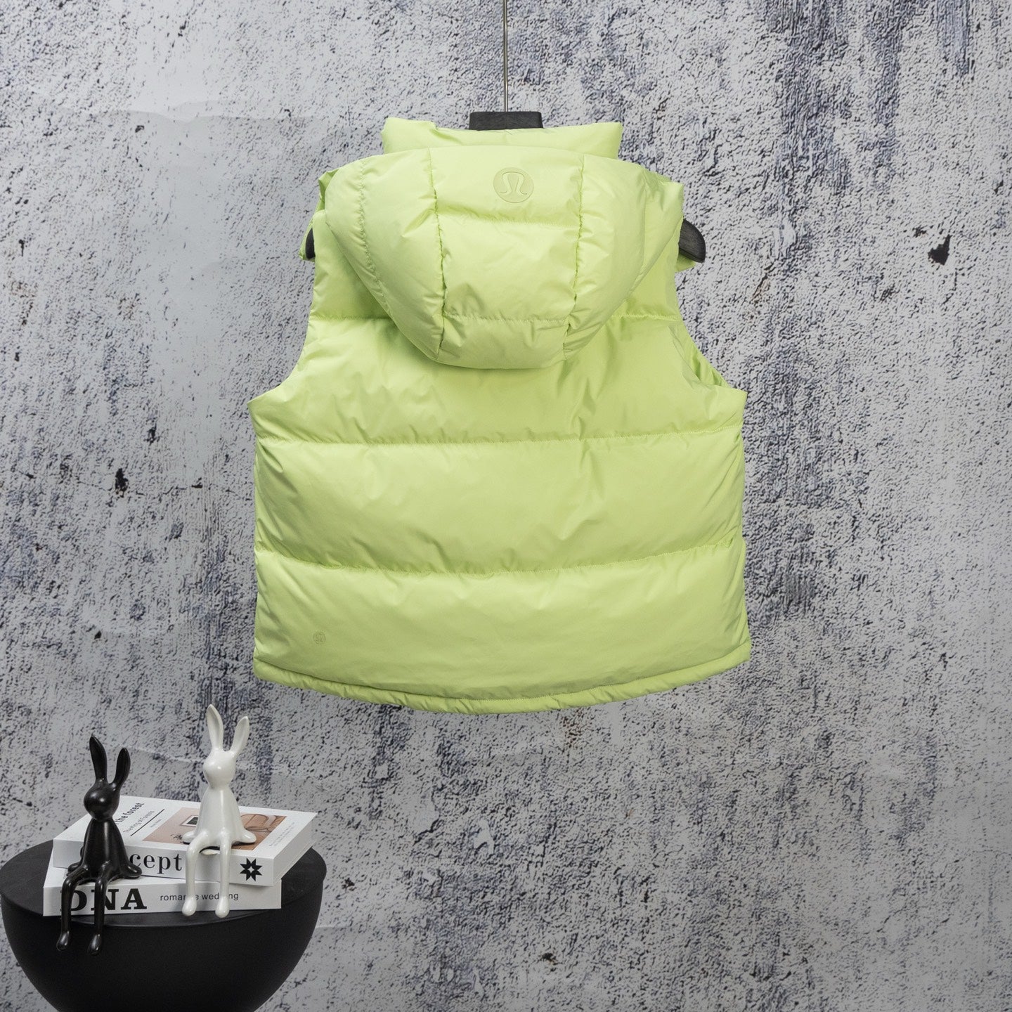 Lime green hooded puffer vest, sleeveless design with zipper front and logo badge