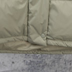 Light sage puffer vest hem with snap placket and round button detail