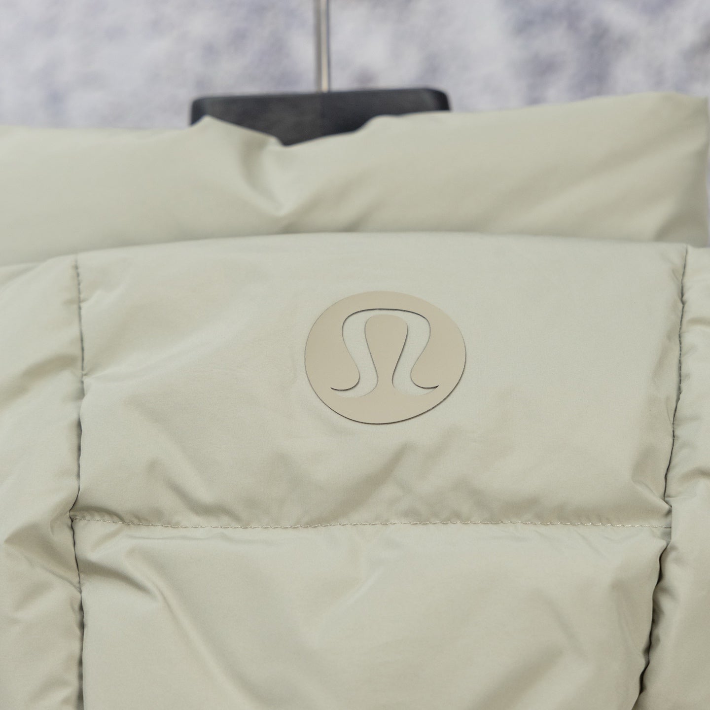 Puffer vest front, light green with circular logo patch