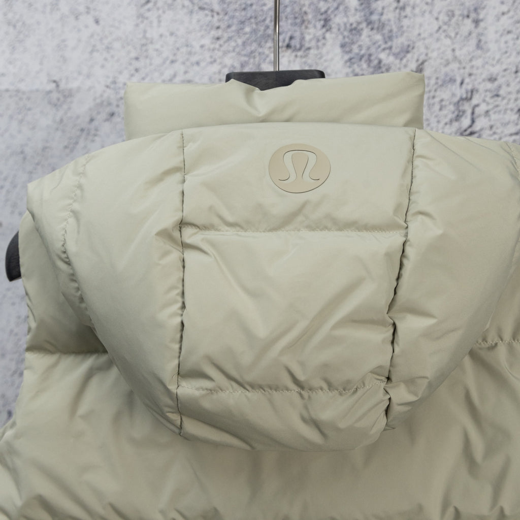 Light sage puffer vest back with centered oval emblem and quilted shoulders