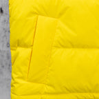 Yellow puffer jacket paneling with quilted blocks and stitched seams