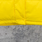Yellow puffer jacket lower front panel with snap and stitched seams