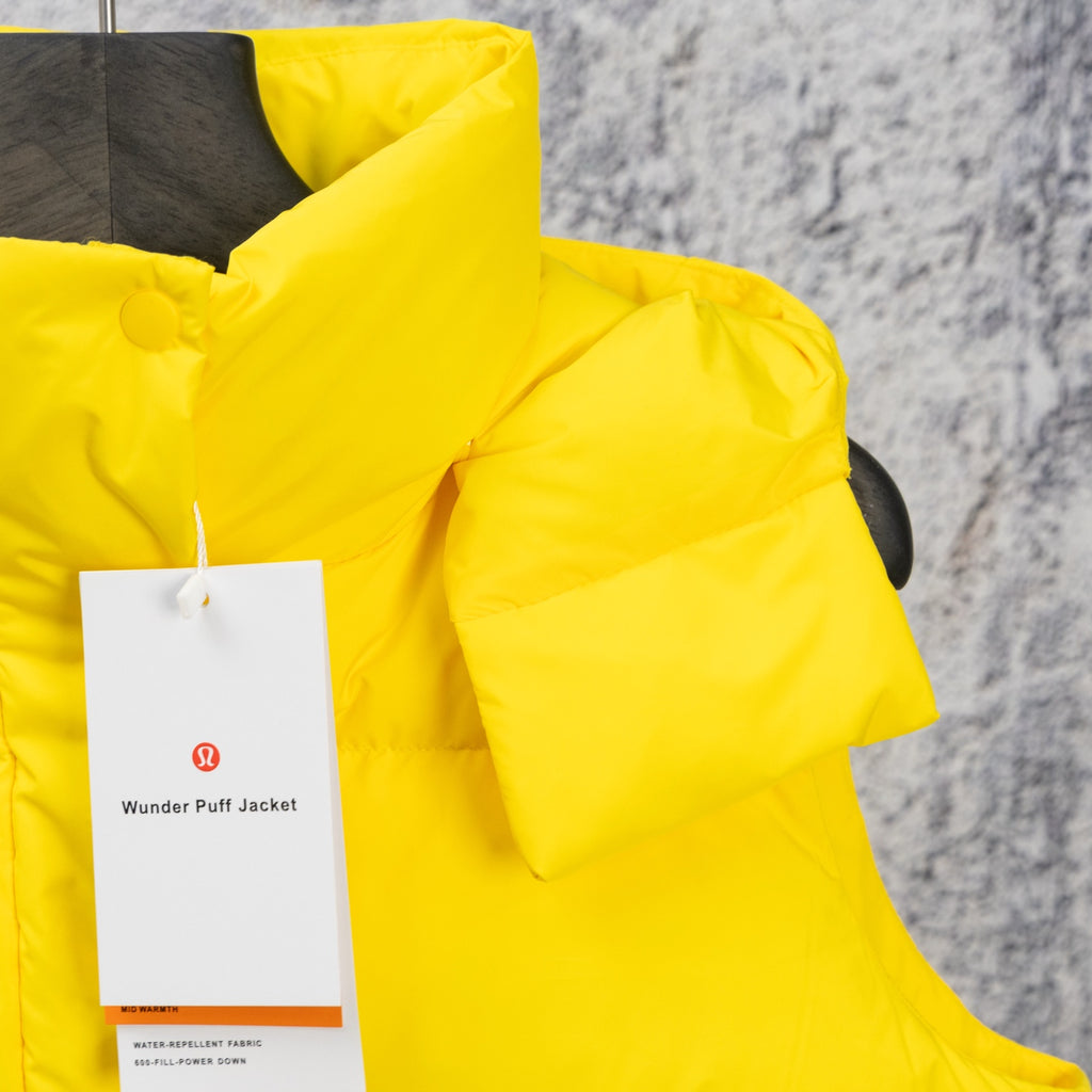 Yellow puffer jacket with hood and front zipper, includes hanging care tag