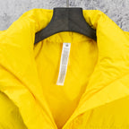Yellow puffer jacket with open hood and interior label on hanger
