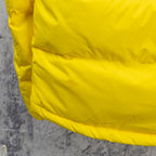 Yellow puffer jacket lower front with small logo badge