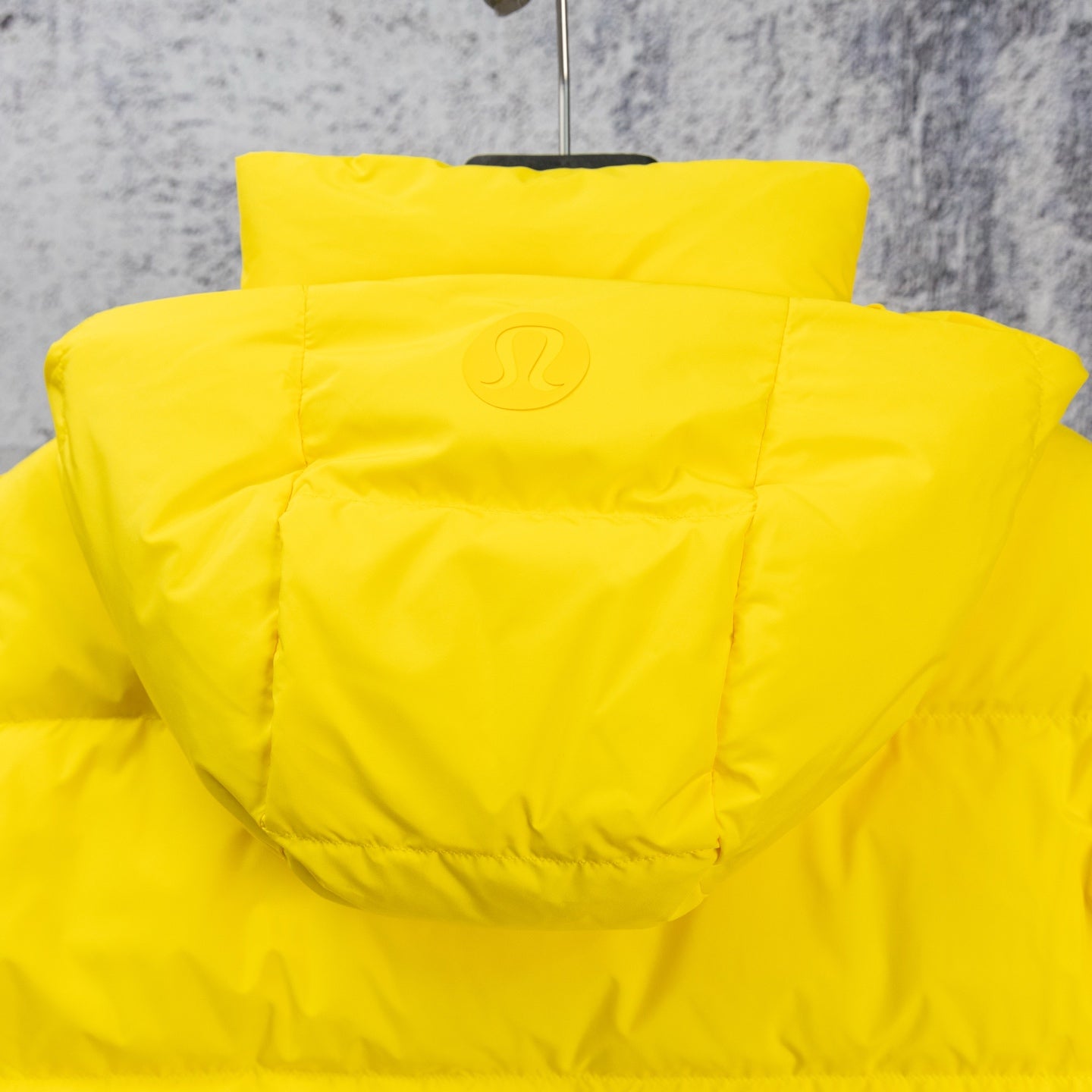 Yellow puffer jacket with adjustable hood and stitched back yoke